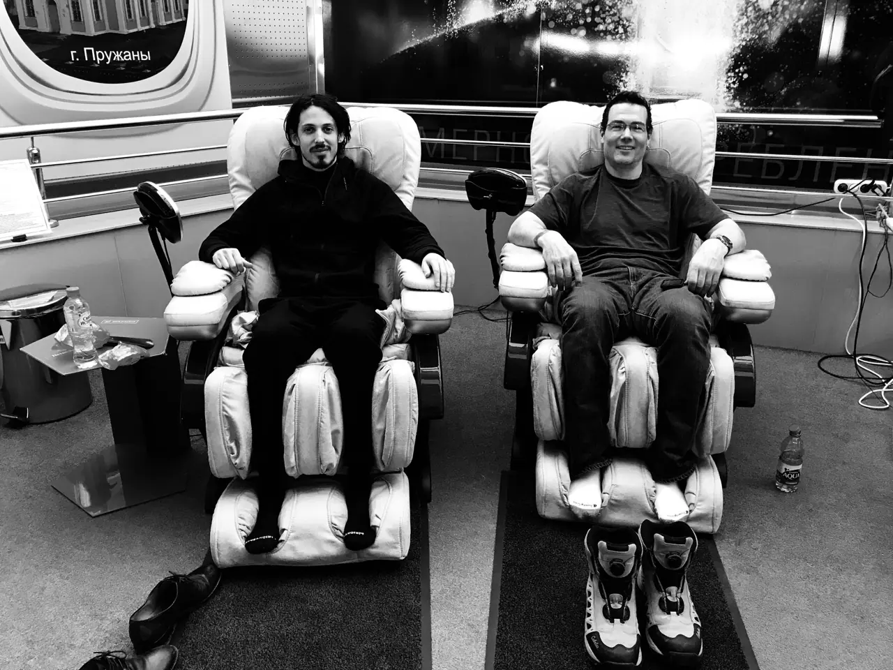 Black and white: two men relaxing in massage chairs backstage on the Black Line tour