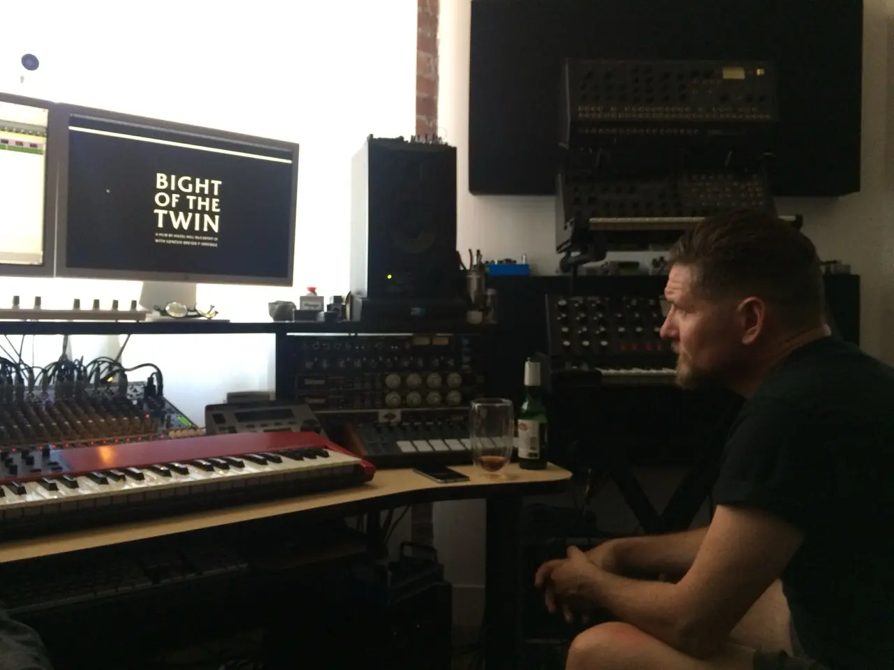 A man watching the Bight of the Twin title card on a studio monitor