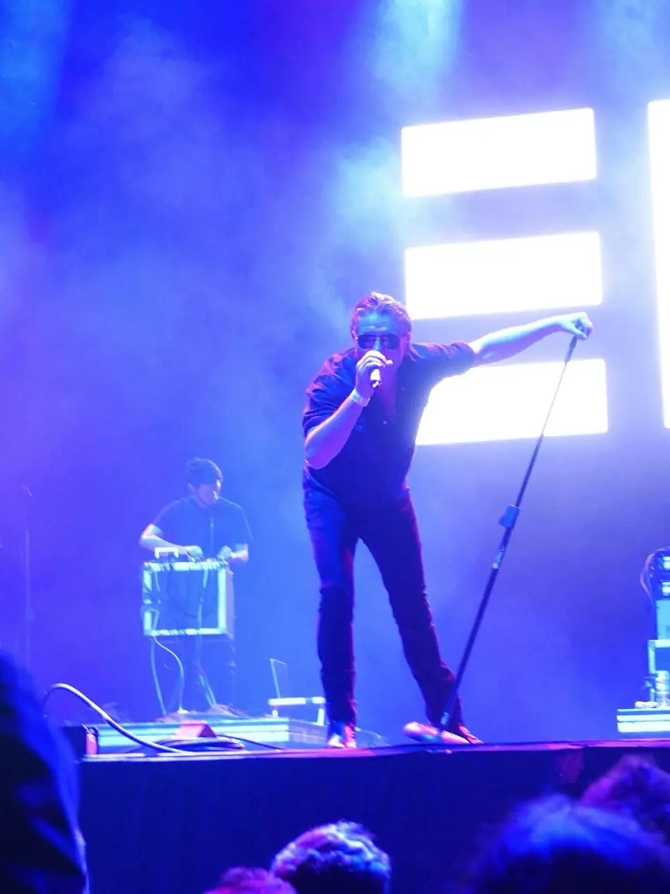 Black Line on stage in blue light, the band’s mark lit up behind them