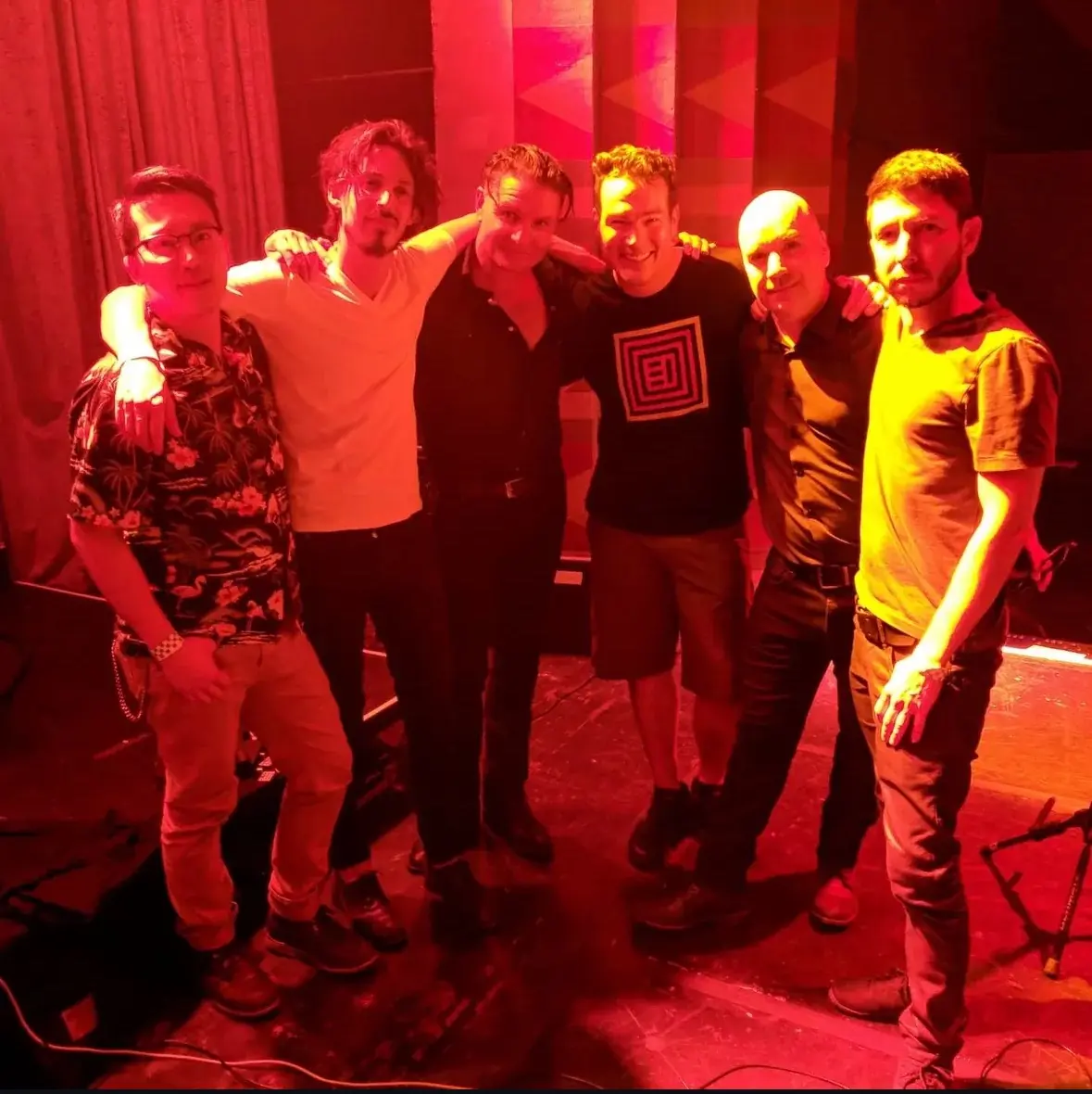 Black Line and Nick, their live engineer, arm in arm on a red-lit stage