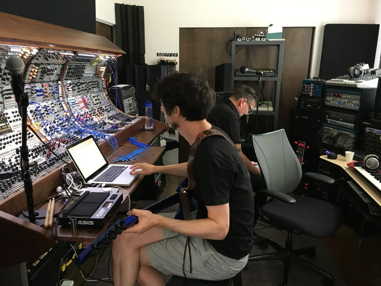 A man working on a laptop at the curved modular console