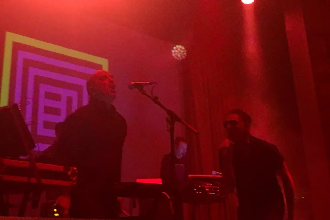Black Line live at the Regent, in red light with the Black Line mark projected behind