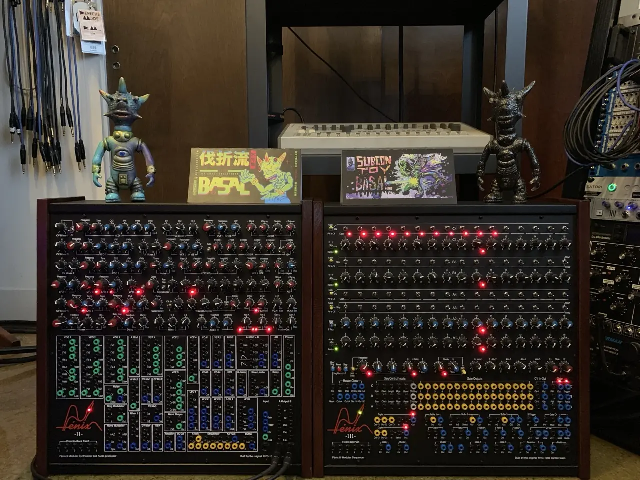 Two wooden modular synth cabinets with toy figures on top