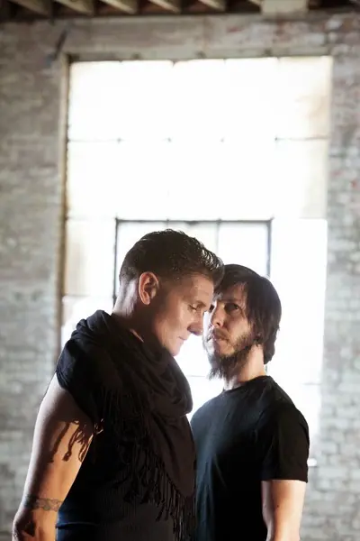 DJMREX — Douglas J. McCarthy and Cyrusrex standing close together by a bright window in a brick room