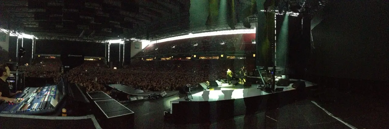 A vast dark venue before the show, the stage lit